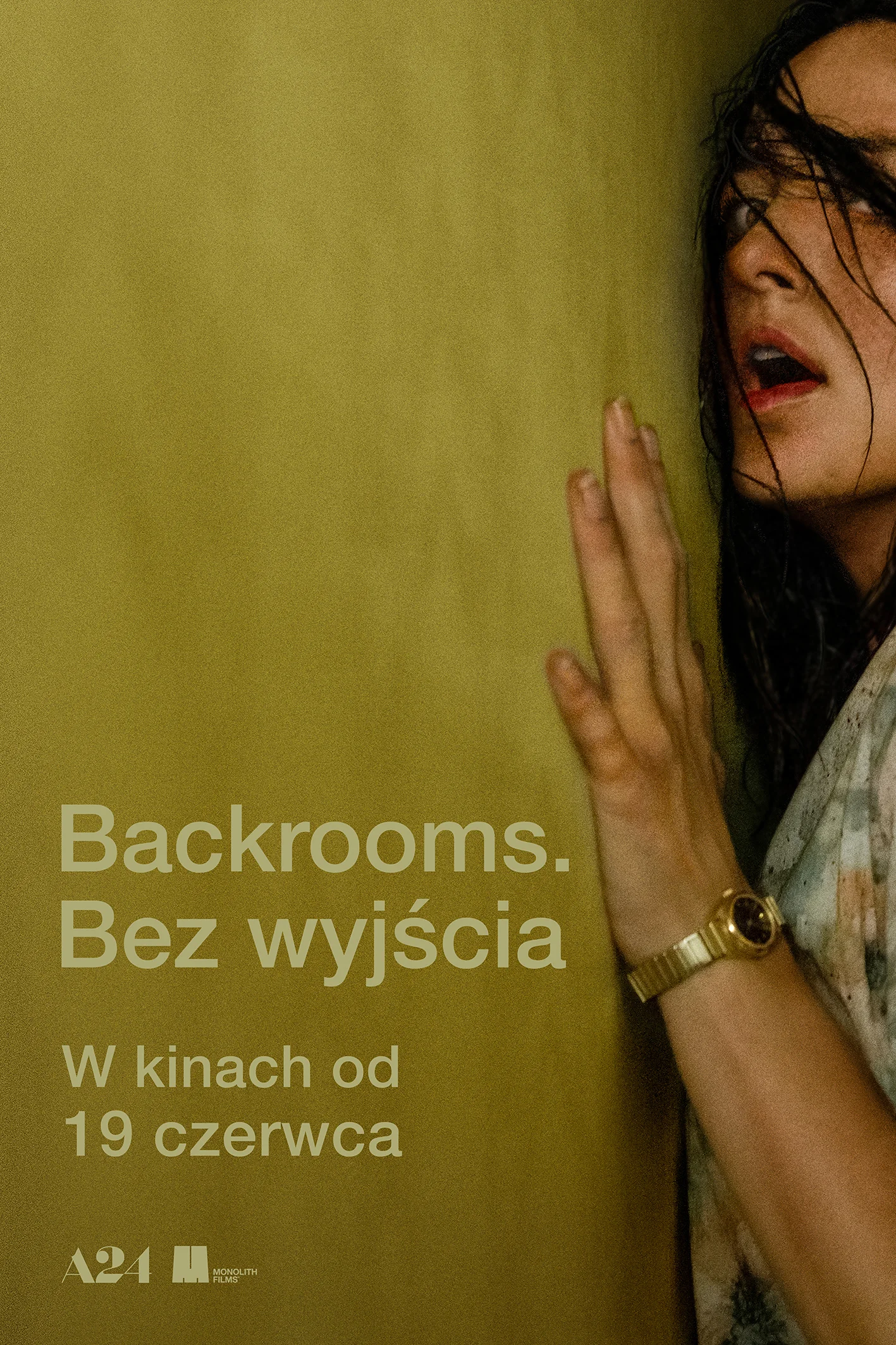 Plakat filmu „Backrooms: Bez wyjścia”: przestraszona kobieta opiera dłoń o żółtą ścianę.
